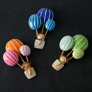 Enamel hot air balloon brooch detail showcasing colorful cute girl pin and metal craftsmanship.