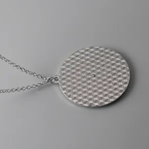 Close-up detail shot of a stylish silver alloy necklace featuring a geometric cube patterned pendant.