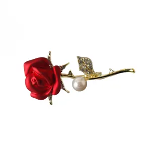 Close-up detail of the elegant red rose brooch, featuring sparkling rhinestones and a white pearl accent.