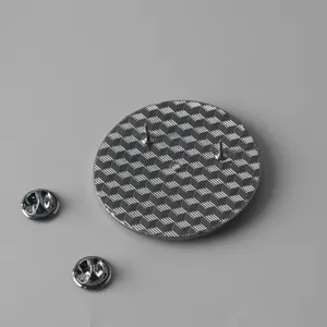 Detailed view of the metal brooch back with dual pins and butterfly clutches, fine texture.