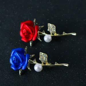 Closeup detail of stunning red and blue rose brooches with sparkling crystal rhinestones and pearls.