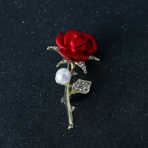 Detailed view of exquisite red rose brooch featuring sparkling rhinestones and elegant gold stem.