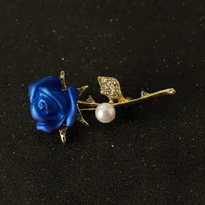 Elegant blue rose brooch featuring sparkling rhinestones and a classic pearl detail accessory.