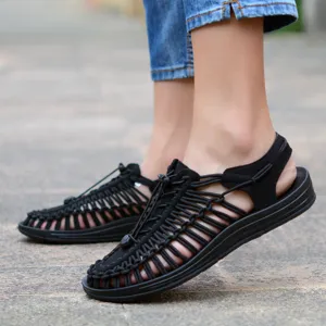 Primer plano de sandalias casuales tejidas negras con diseño de parte superior.