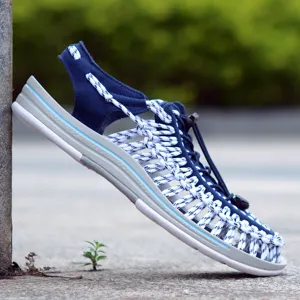 Detalle de sandalias tejidas con cordones blancos y azules y una suela cómoda.