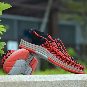 Detalle de sandalias trenzadas de cordón, zapatos de verano negros y rojos para hombres y mujeres.