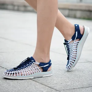 Detalle de uso de sandalias trenzadas azules y blancas, cómodos zapatos de verano.