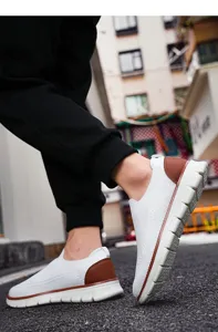 Close-up of men's breathable flyknit casual shoes with white mesh and brown heel accents.
