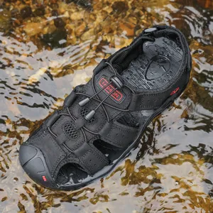 Detail view of black outdoor water sandals with mesh, bungee lacing, and toe protection in stream.
