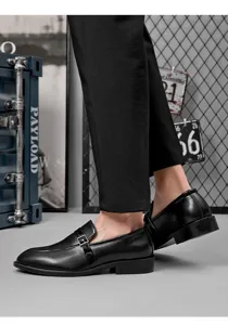 Gros plan de chaussures de ville habillées pour hommes en cuir noir avec boucle en métal.