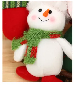Close up detail of cute Christmas snowman plush toy with knitted scarf and red shoes festival decor.