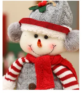 Nahaufnahme der niedlichen Weihnachtsschneemann Plüschpuppe mit grauer Strickmütze und Schal.