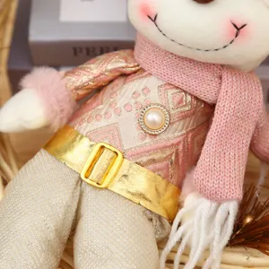 Christmas plush doll ornament close-up, festive pink and gold outfit with sparkly holiday decor.