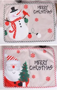 Christmas placemat detail view featuring Santa and snowman print, festive fabric table decor.