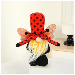 Close-up detail of cute ladybug gnome plush doll ornament with red polka dot hat and wings.