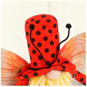 Close-up detail of a festival gnome doll with red ladybug hat, wings and yellow beard.