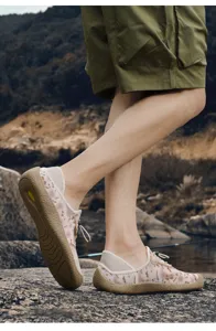 Vista detallada zapatos casuales de malla en fondo rocoso, diseño flexible y transpirable.