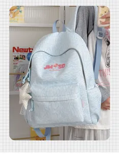 Vista detallada de la mochila escolar azul jaspeado casual con bordado y colgante de estrella.