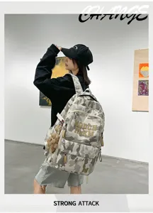 Detail view of the stylish camouflage student backpack with cute bear pendant in art gallery.