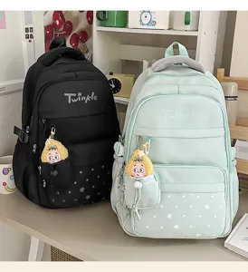 Close-up of stylish student backpack with star print, multi-compartment and cute doll pendant.