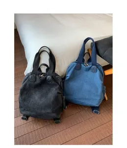 Vue détaillée du sac à dos multifonction en denim lavé rétro pour femme en noir et en bleu.