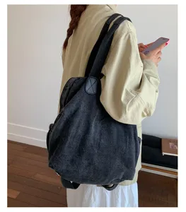 Vue détaillée du sac à dos convertible en denim lavé rétro, mettant en valeur sa texture.