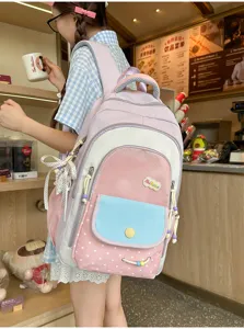 Detailansicht des pastellfarbigen Rucksacks mit mehreren Taschen und niedlichem Pünktchen-Muster.
