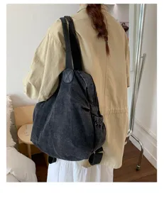 Vue détaillée du sac à dos en denim lavé vintage montrant son design polyvalent et son porté.