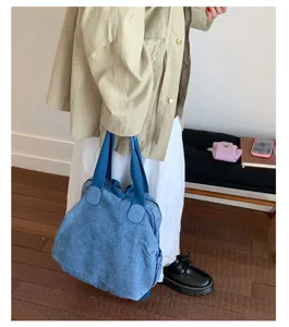 Vue détaillée du sac à dos en denim lavé rétro montrant le tissu bleu et les sangles robustes.