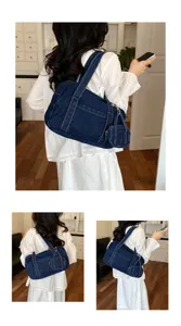 Detailed view of the stylish dark blue denim shoulder bag, showing fine stitching and casual design.