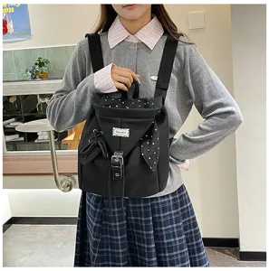 Detailansicht des schwarzen Damen Rucksacks mit süßen Punkte-Klappen und Schleifen-Details.