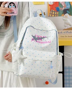Detailed close-up of Japanese cute polka dot canvas backpack with star print and pendant.