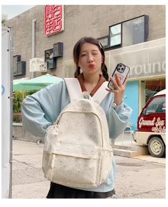 Vue détaillée du joli sac à dos d'étudiant en toile blanche avec motif de cœur mignon.