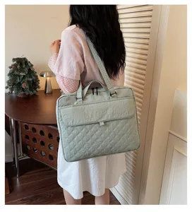 Dettaglio della borsa tote per laptop in nylon trapuntato verde chiaro per commuting.