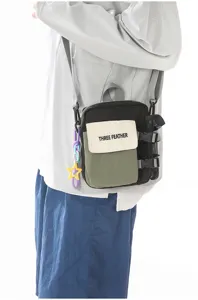 Détail en gros plan du sac bandoulière tactique colorblock avec bretelles réglables et poche.