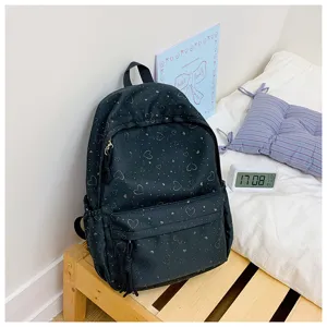 Vue de détail d'un sac à dos noir pour étudiant avec motifs de cœurs mignons, idéal pour l'école.