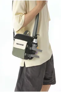 Gros plan detaille du sac bandouliere tactique bloque en couleur avec sangle et poche.