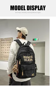 Detail view of large capacity camouflage student backpack with multiple pockets and trendy letters.