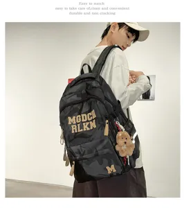 Detailed view of the stylish camouflage backpack with letter prints and cute doll pendant.