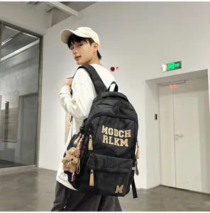 Fashion camouflage large capacity school backpack with letters and cute bear pendant for students.