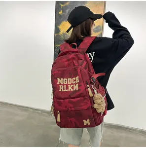 Fashionable red camouflage student backpack, large capacity, ergonomic spine protection design.