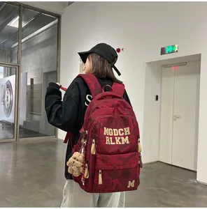 Details of the red camo student backpack displaying fashion letter prints and roomy compartments.