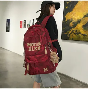Detailed view of the stylish red camouflage student school backpack worn in an artistic setting.