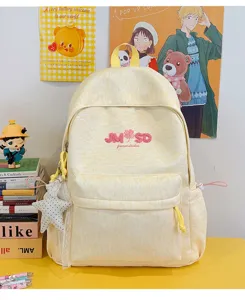 Detalle de mochila escolar amarilla, bolso grande con bolsillo frontal y bordado elegante.