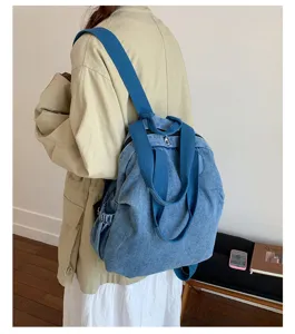 Vue détaillée du sac à dos convertible en denim lavé bleu et cabas d'épaule au quotidien.