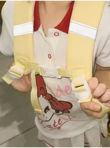 Children anti-lost backpack detail view featuring secure chest buckle, yellow straps and reflective strips.