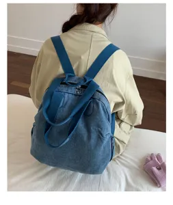 Vue détaillée du sac à dos en denim bleu lavé vintage montrant doubles bretelles et style.