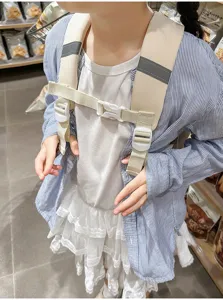 Children safety backpack harness detail view, beige color block, secure buckles and straps.