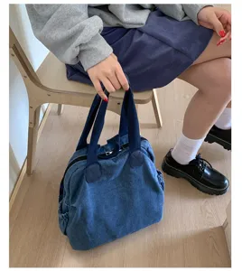 Vue détaillée du sac cabas en denim lavé vintage avec double poignées et design décontracté.