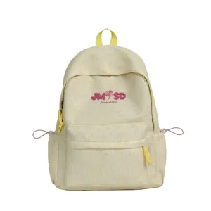 Vista detallada de la elegante mochila escolar amarilla con logotipo de trébol bordado.